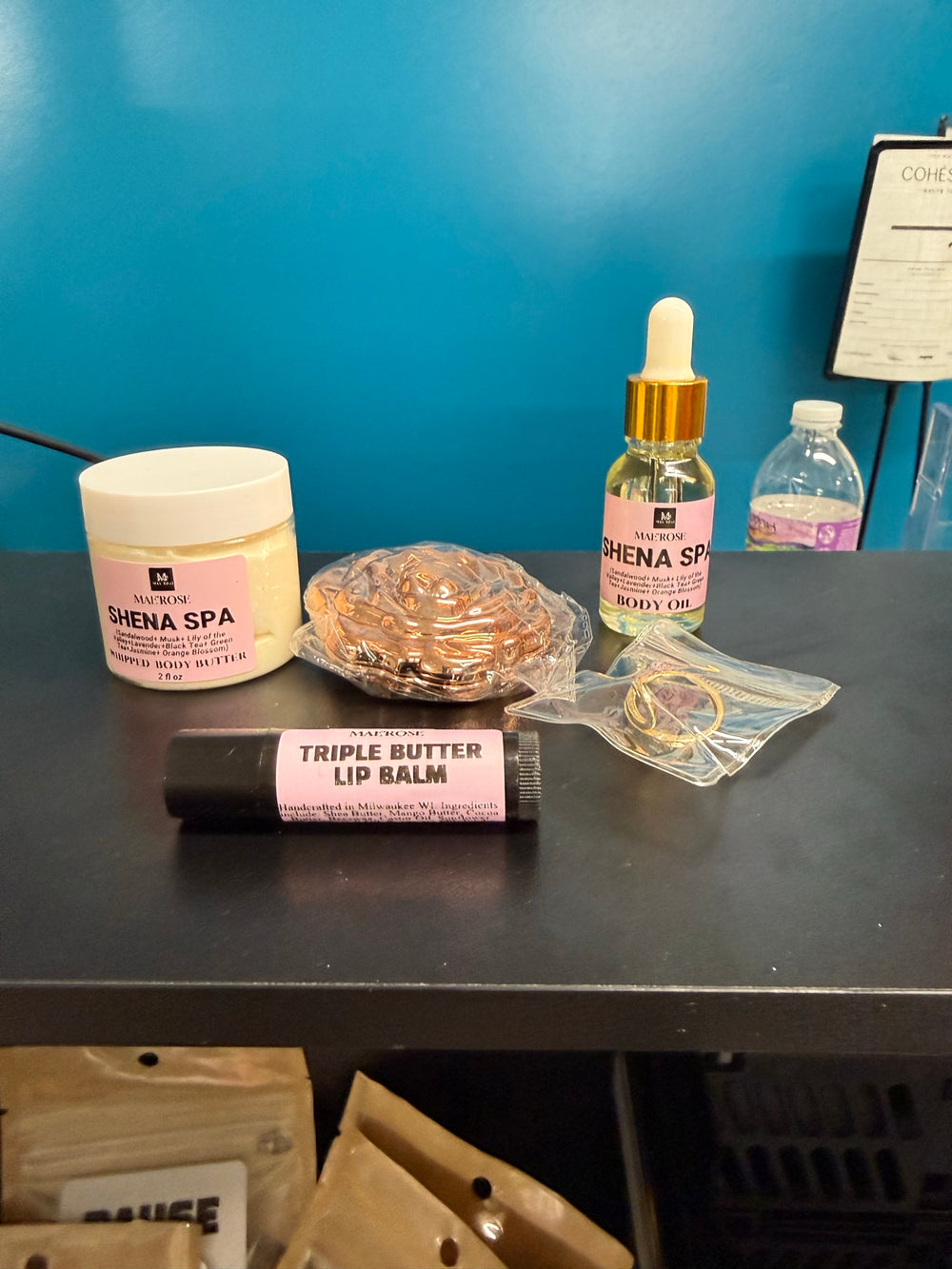 Shena's Spa gift set contents: whipped body butter, body oil, triple butter lip balm and a compact mirror. Styling varies by bag.