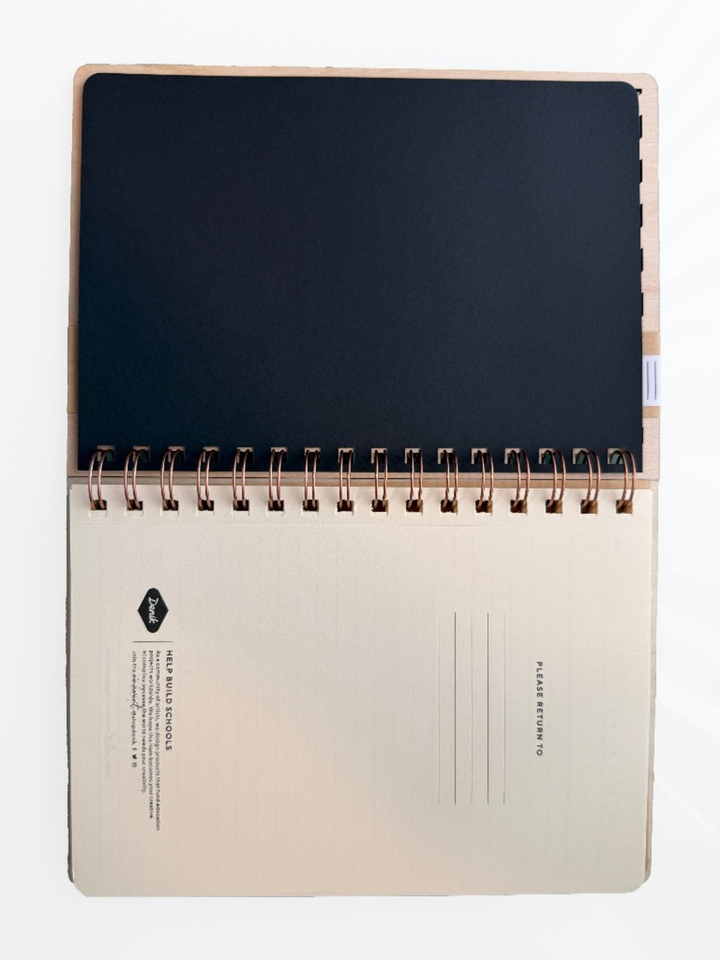 Detail of the copper wire binding and cut wood cover on the Denik notebook