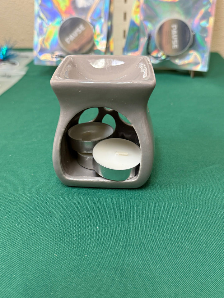 Gray ceramic salt and wax warmer with tealights, shown on a plain backdrop
