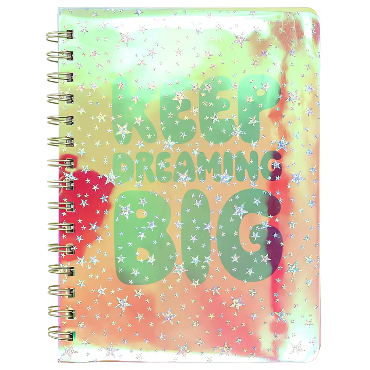 Angled view of the Keep Dreaming Big notebook showing the shifting holographic finish and gold spiral binding
