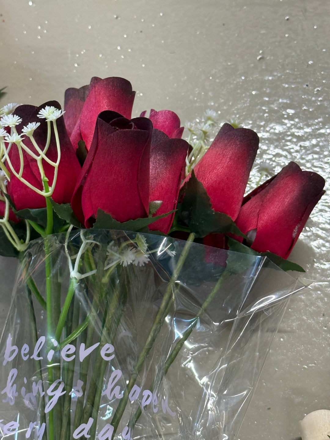 Deep red wooden rose bouquet wrapped with baby’s breath